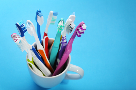 Toothbrushes in cup on blue background