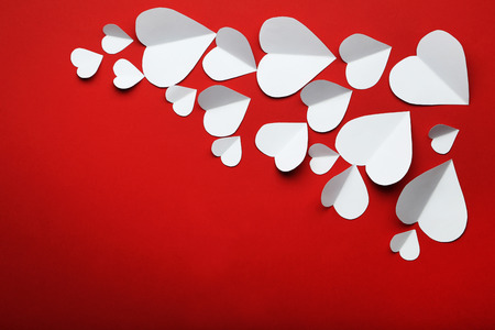 White paper hearts on red backgroundの写真素材