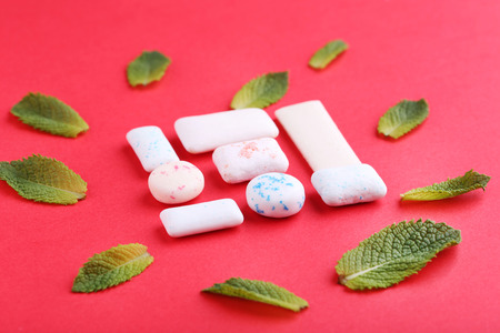 Chewing gums with mint leafs on red backgroundの写真素材