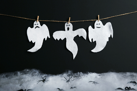 Halloween ghosts hanging on black backgroundの写真素材