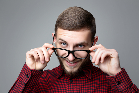 Portrait of young man in glasses on grey backgroundの写真素材