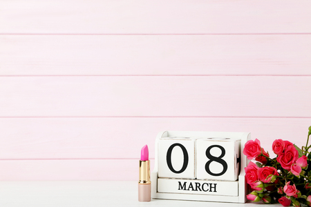 Calendar cubes with flowers and lipstick on pink backgroundの写真素材
