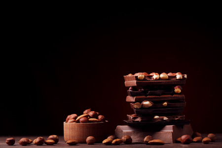 Chocolate pieces with nuts on wooden tableの写真素材