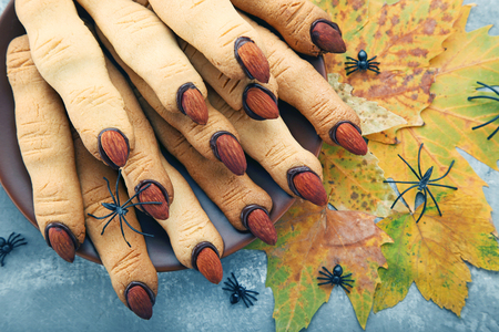 Halloween finger cookies in plate on wooden tableの写真素材