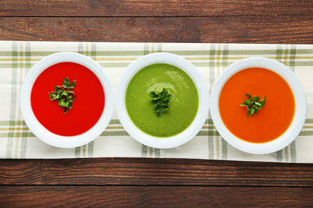 Vegetable cream soup with parsley on wooden tableの写真素材