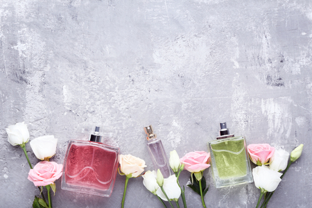 Perfume bottles with flowers on grey wooden tableの写真素材