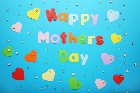 Inscription Happy Mothers Day with paper hearts on blue backgroundの写真素材