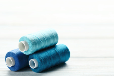 Colourful thread spools on white wooden tableの写真素材