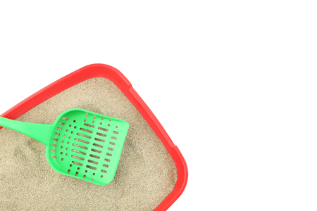 Red toilet tray with sand and scoop on white backgroundの写真素材