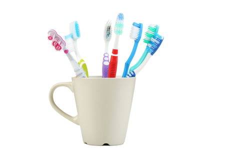 Toothbrushes in cup isolated on white backgroundの写真素材