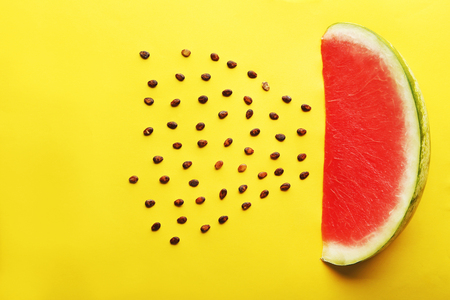 Slice of watermelon with seeds on yellow backgroundの写真素材