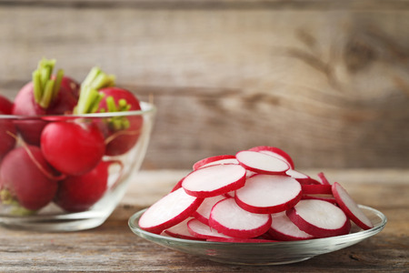 Sliced red radish in plate on grey wooden tableの写真素材