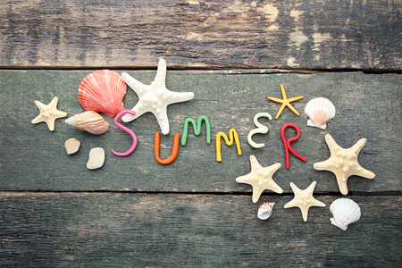 Inscription Summer by plasticine with seashells on grey wooden tableの写真素材