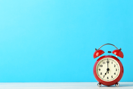 Red alarm clock on blue background