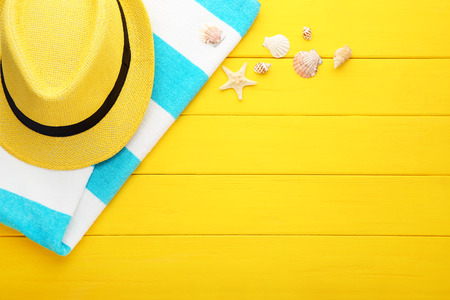 Summer accessories with seashells on yellow wooden tableの写真素材