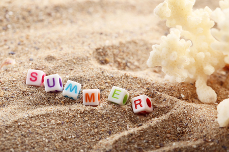 Inscription Summer by cubes with coral on beach sandの写真素材