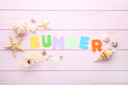 Inscription Summer with seashells on pink wooden tableの写真素材