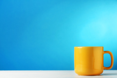 Yellow cup on blue backgroundの写真素材