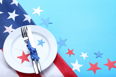 American flag with plate and kitchen utensils on blue backgroundの写真素材