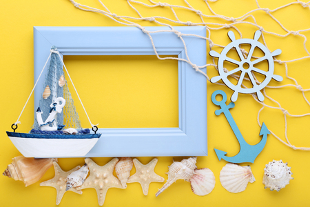 Wooden frame with seashells on yellow backgroundの写真素材