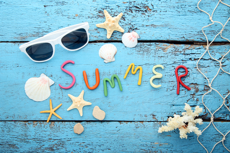 Inscription Summer by plasticine with seashells on blue wooden tableの写真素材