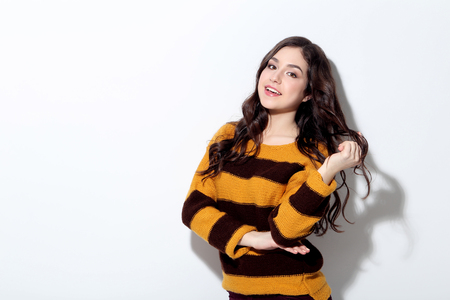 Beautiful young woman in sweater on white backgroundの写真素材