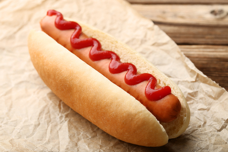 Hot dog with ketchup on wooden tableの写真素材