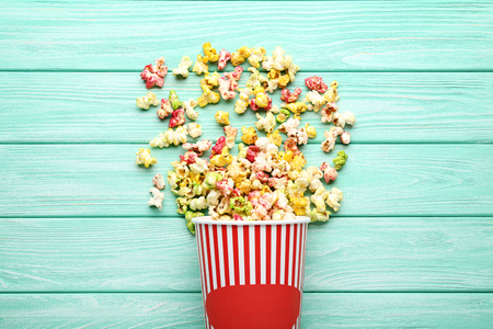 Sweet popcorn in striped bucket on mint wooden tableの写真素材