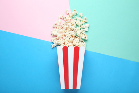 Popcorn in striped bucket on colorful backgroundの写真素材