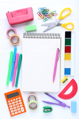 School supplies with blank sheet of paper on wooden tableの写真素材