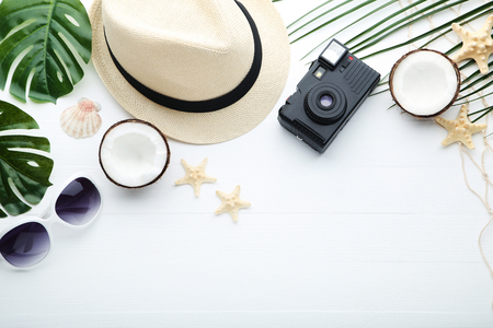 Summer accessories with coconuts and retro camera on wooden tableの写真素材