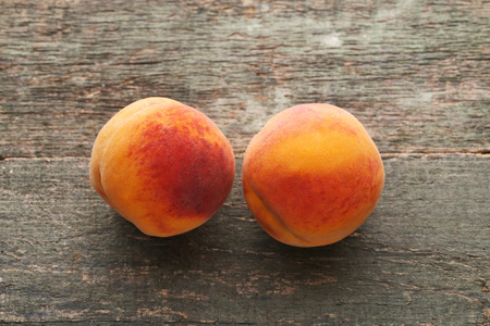 Ripe peaches fruit on wooden tableの写真素材