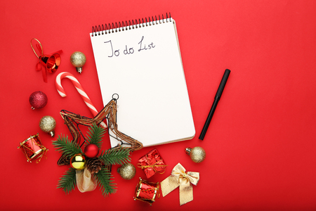 To do list in notepad with christmas decorations on red backgroundの写真素材