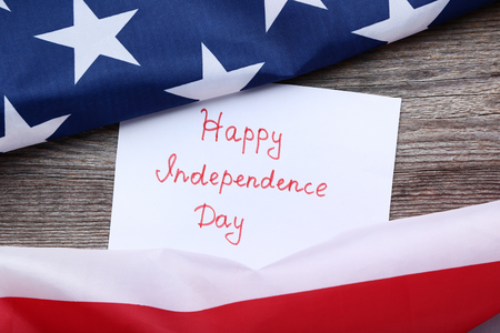 American flags and paper with inscription Happy Independence Dayの写真素材