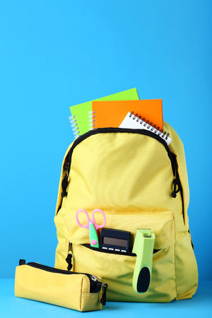 Yellow backpack with school supplies on blue backgroundの写真素材