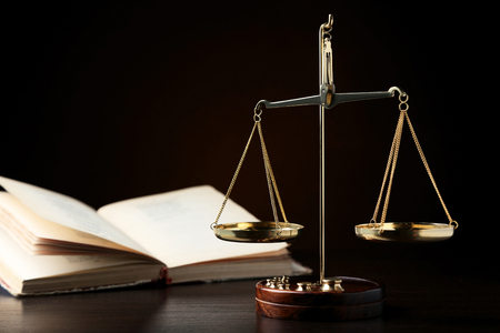 Scales of justice with book on wooden tableの写真素材