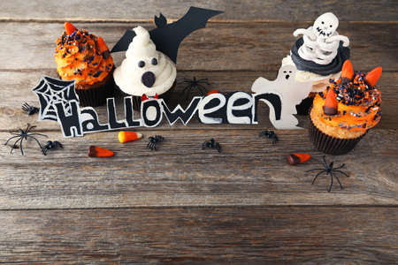 Halloween cupcakes with candies on grey wooden tableの写真素材