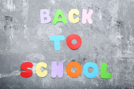 Inscription Back To School on grey wooden table