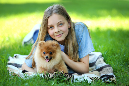 Young girl with pomeranian dog in the parkの写真素材