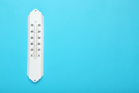 White thermometer on blue background