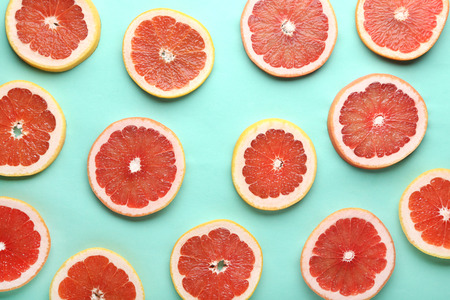 Ripe grapefruit slices on mint backgroundの写真素材