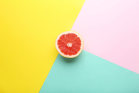 Ripe grapefruit slice on colorful backgroundの写真素材