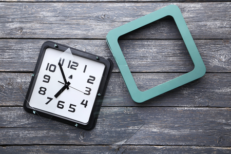 Broken clock on grey wooden tableの写真素材