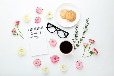 Rose flowers with cup of coffee and cookies on white backgroundの写真素材