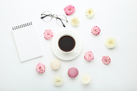 Rose flowers with cup of coffee and macarons on white backgroundの写真素材