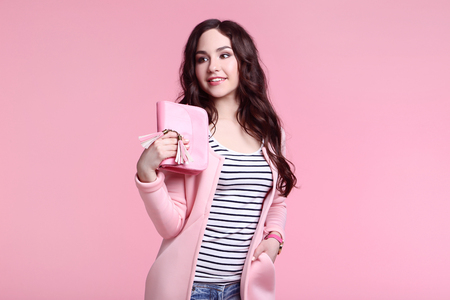 Beautiful woman in fashion clothes on pink backgroundの写真素材