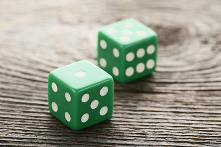 Green dice on grey wooden tableの写真素材