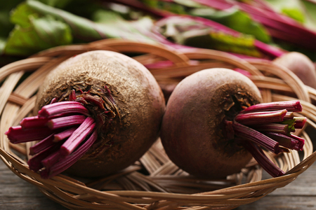 Fresh and ripe beets in basket on wooden tableの写真素材