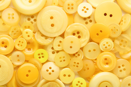 Yellow sewing buttons on white backgroundの写真素材