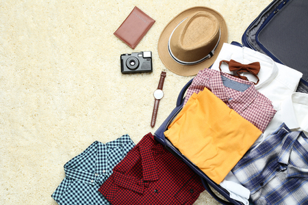 Opened suitcase with clothes, camera and passportの写真素材
